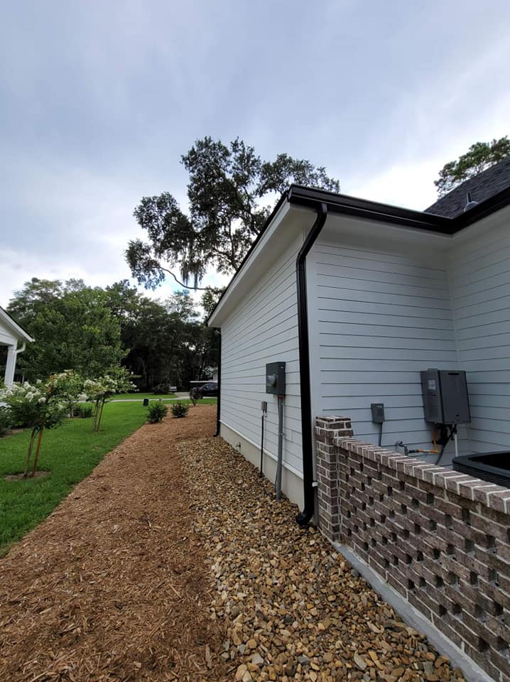 Seamless black 6-inch K-style gutters installed on a white Lowcountry home
